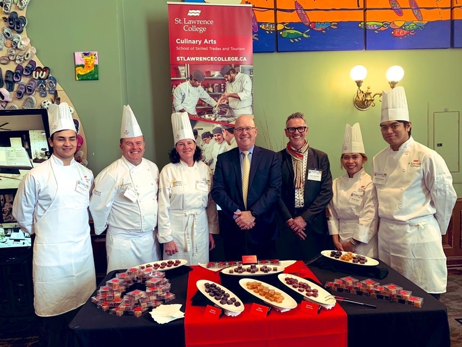 SLC student Zachary Vecchio, SLC Chef Professors Richard Hendy and Leslie Leacy, MPP Steve Clark, SLC President and CEO Glenn Vollebregt, SLC students Marilou Sabad and Lemuel Yamzon stand in front of a table with trays of pate de fruit